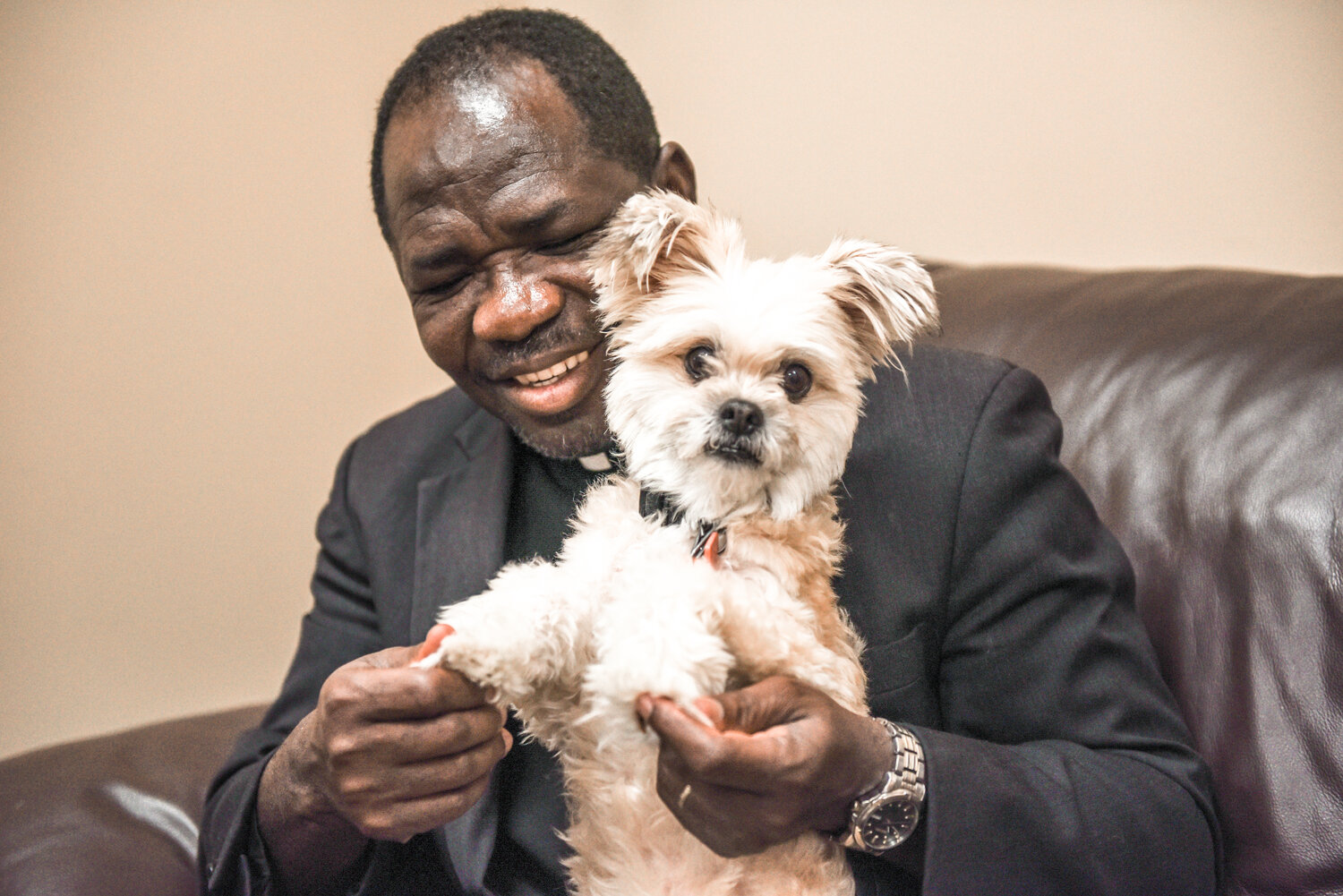 Father Henry Ussher, pastor of St. Clement Parish in St. Clement, St. Joseph Parish in Louisiana and the Mission of Queen of Peace in Clarksville, introduces a visitor to his dog, Africa, a Shih Tzu mix.